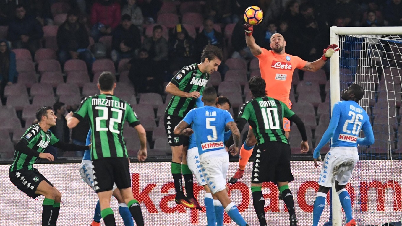 Brankár Neapolu Pepe Reina boxuje loptu v zápase proti Sassuolu.