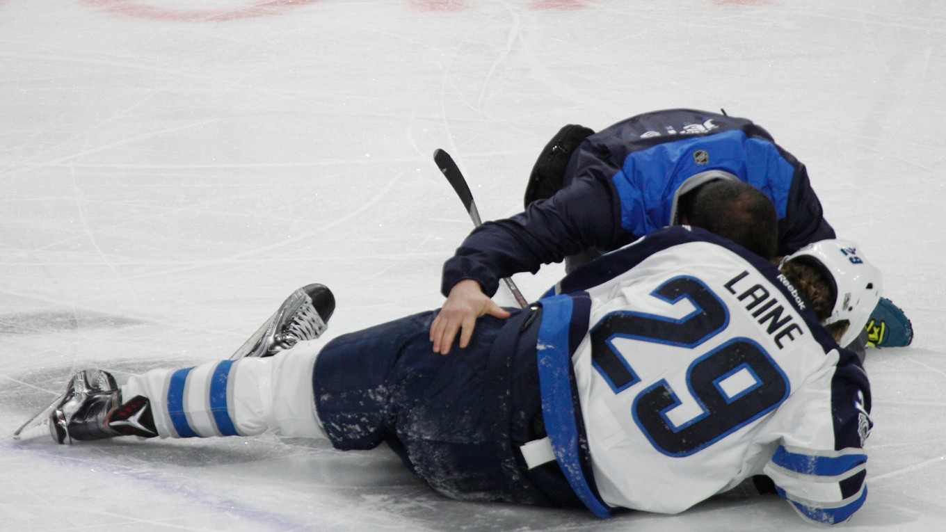 Patrik Laine zostáva ležať na ľade po zákroku Jakea McCabea.