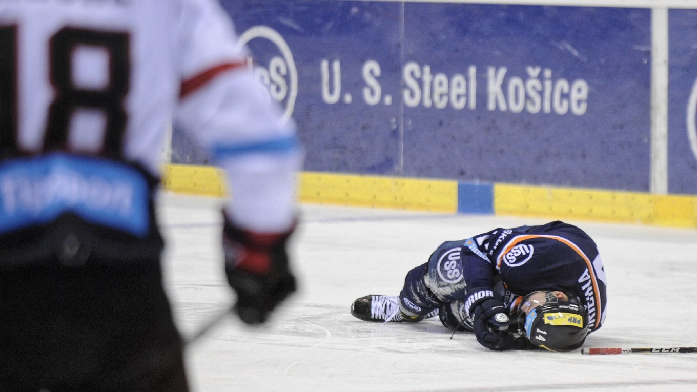Tomáš Hričina (vpravo) zostal po zákroku Michala Handzuša iba ležať na ľade.