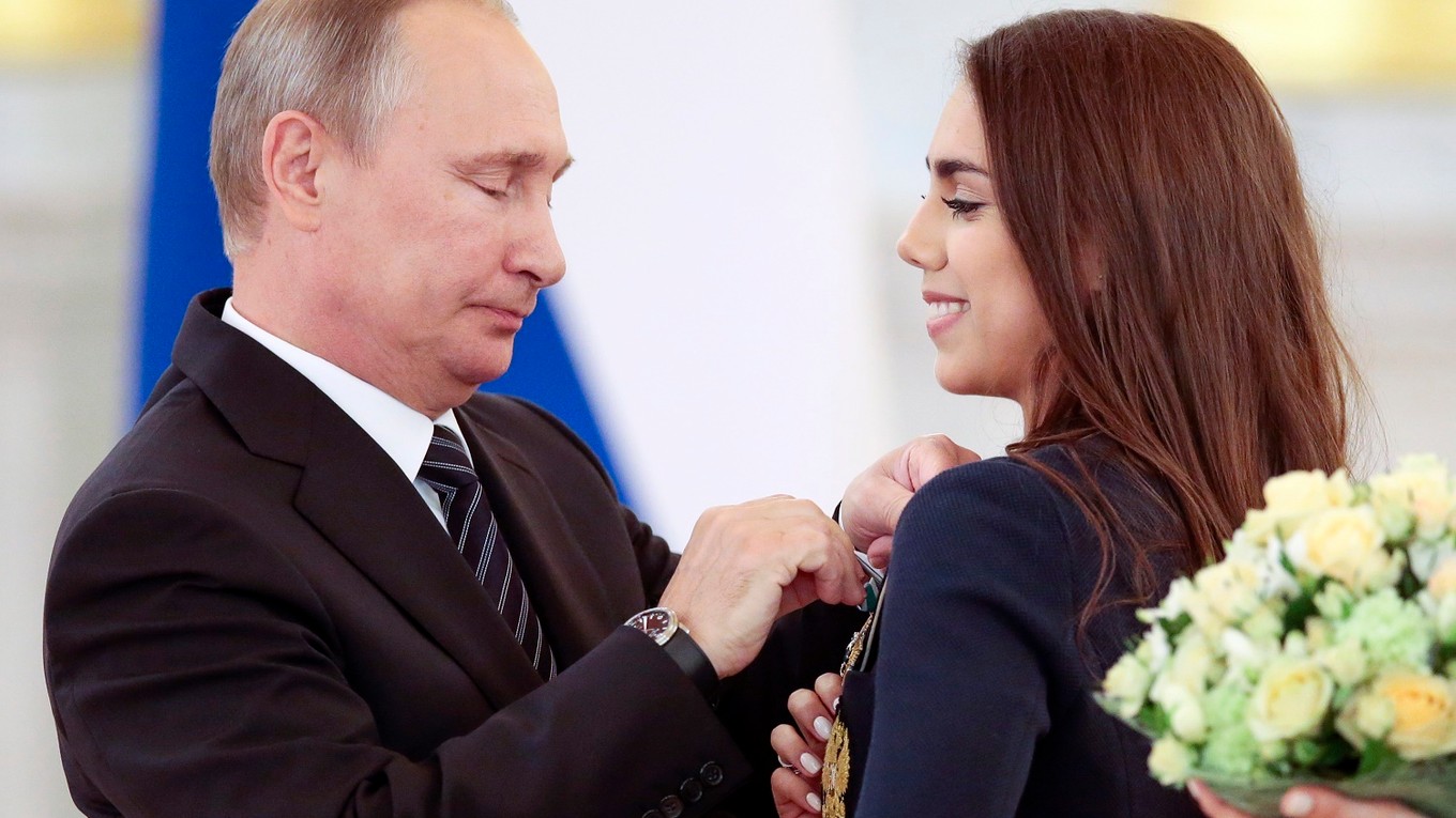 Ruský prezident Vladimir Putin pripína vyznamenanie zlatej medailistke, ruskej atlétke v modernej gymnastike Margarite Mamunovej počas odovzdávania vyznamenaní pre členov ruskej olympijskej výpravy po ich príchode z OH 2016 v Rio de Janeiro 25. augusta 2016.