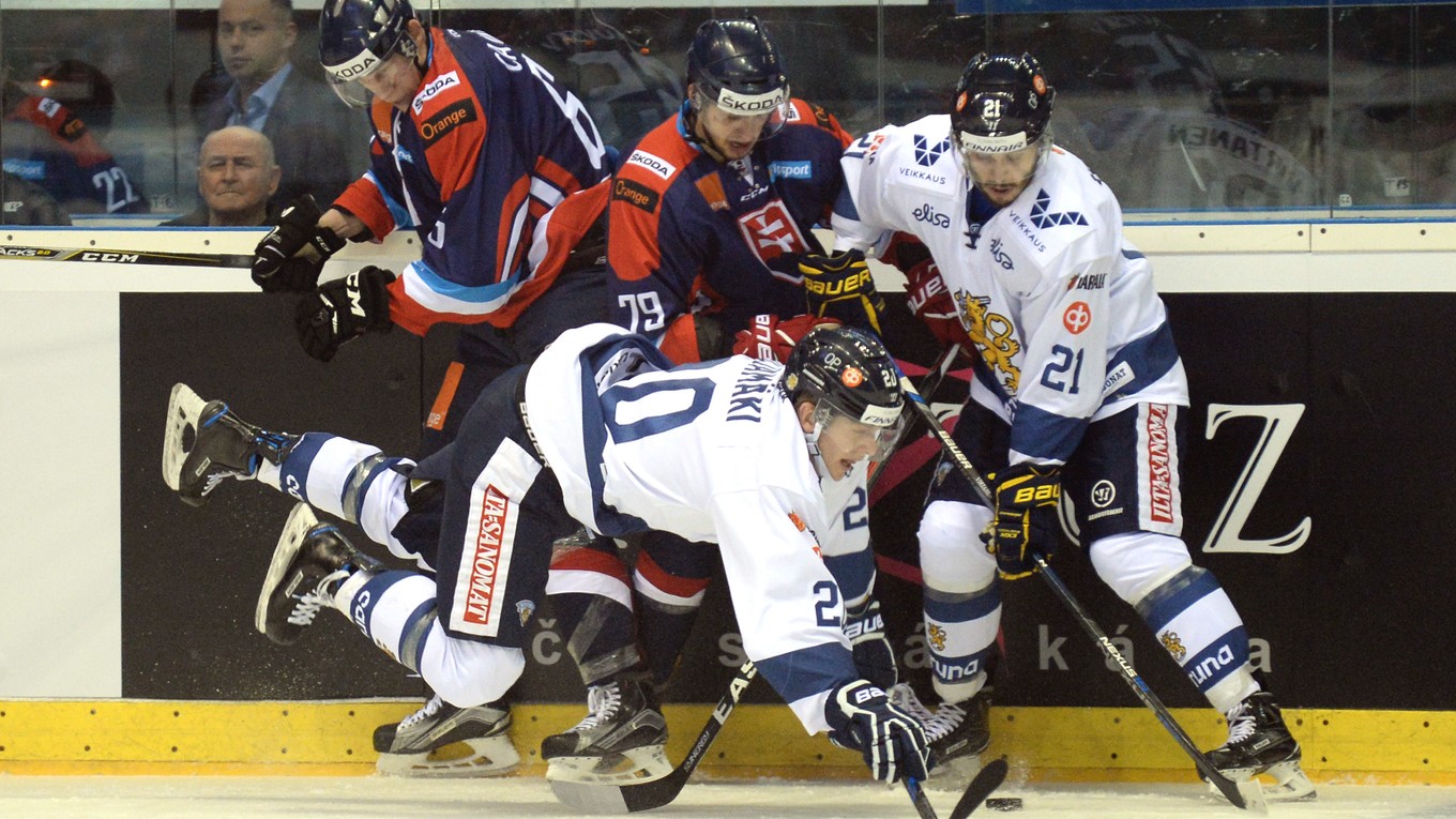 Dvaja slovenskí hokejisti Michal Čajkovský (vľavo) a Libor Hudáček bojujú pri mantineli o puk s dvojicou hráčov Fínska.