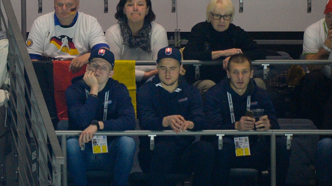Na snímke slovenskí hokejoví reprezentanti dolný rad zľava Pavol Skalický, Tomáš Zigo a Tomáš Matoušek sledujú svojich budúcich súperov počas zápasu základnej A - skupiny USA - Nemecko na MS v ľadovom hokeji v Kolíne nad Rýnom.