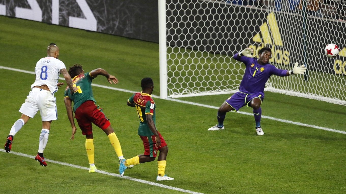 Arturo Vidal (vľavo) strieľa otvárací gól zápasu do siete Kamerunu.