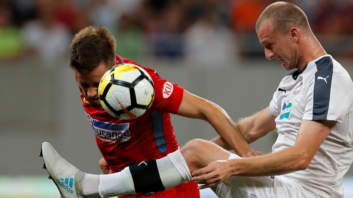 Futbalista Steaua Bukurešť Mihai Pintilii (vľavo) a hráč Viktorie Plzeň Michael Krmenčík bojujú o loptu.