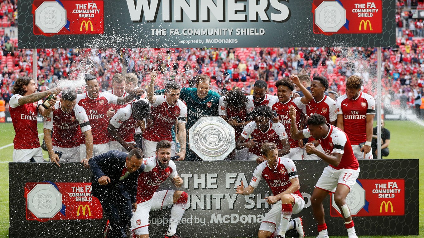 Futbalisti Arsenalu pózujú s víťaznou trofejou.