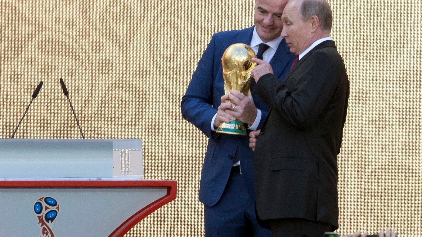 Ruský prezident Vladimir Putin (vpravo) a prezident Medzinárodnej futbalovej federácie (FIFA) Gianni Infantino držia trofej pre víťaza futbalových MS.