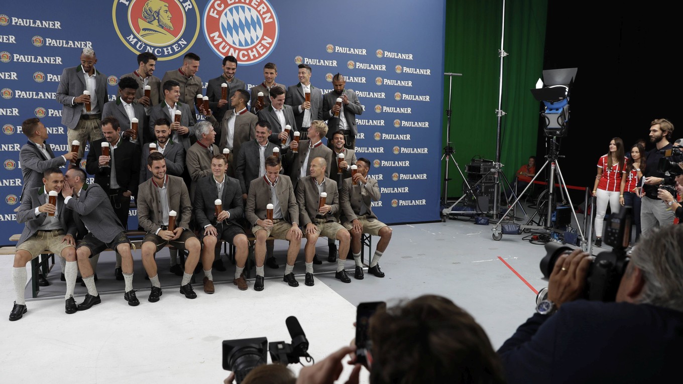 Futbalisti Bayernu Mníchov v tradičnom bavorskom oblečení počas fotenia pre spoločnosť na výrobu piva.