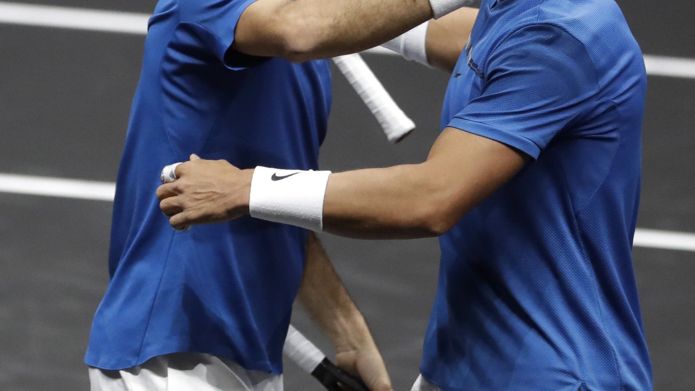 Roger Federer (vľavo) sa raduje s Rafaelom Nadalom z víťazstva.