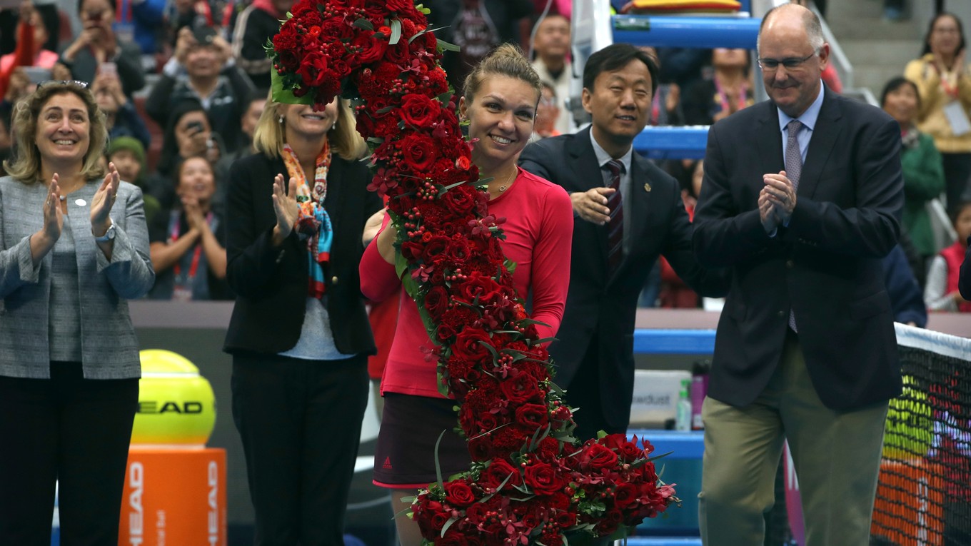 Simona Halepová pózuje s veľkou kyticou v tvare jednotky, ktorá symbolizuje pozíciu novej líderky svetového rebríčka.