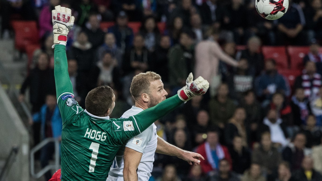 Adam Nemec sa snaží zasiahnuť loptu hlavičkou vo vzdušnom súboji s brankárom Hoggom.