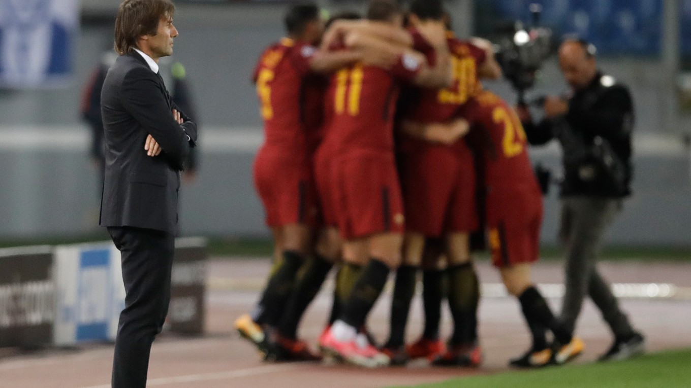 Futbalisti AS Rím sa radujú po jednom z gólov, v popredí sklamaný tréner Chelsea Antonio Conte.