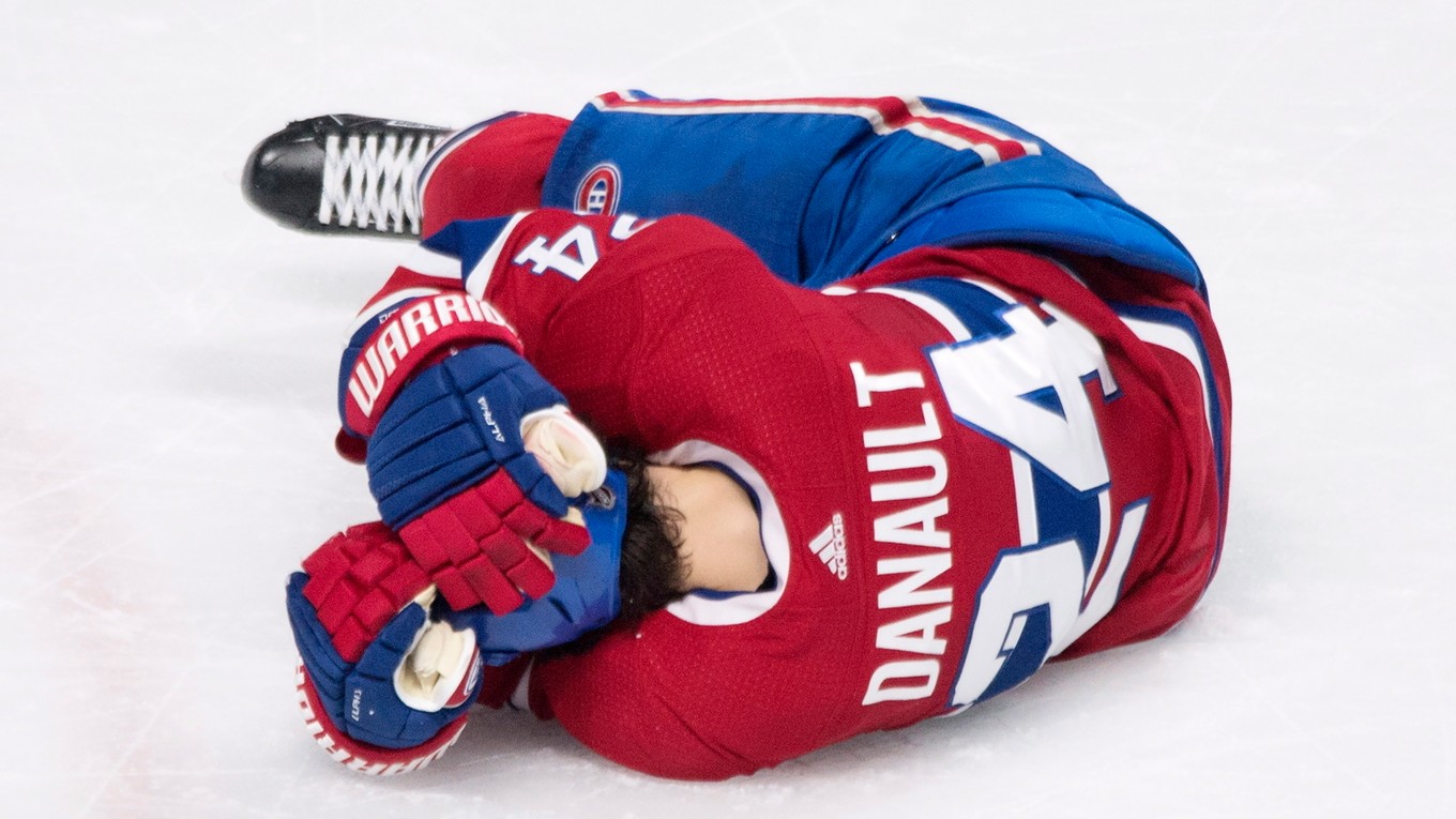 Hokejista Montrealu Canadiens Phillip Danault leží na ľade po tom, čo ho slovenský obranca v drese Bostonu Bruins Zdeno Chára nešťastne trafil strelou od modrej čiary do hlavy.