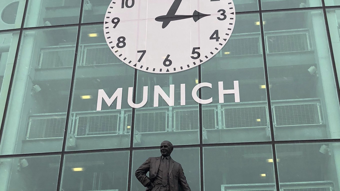 Pamätné hodiny nad sochou Matta Busbyho na štadióne Manchestru United Old Trafford.