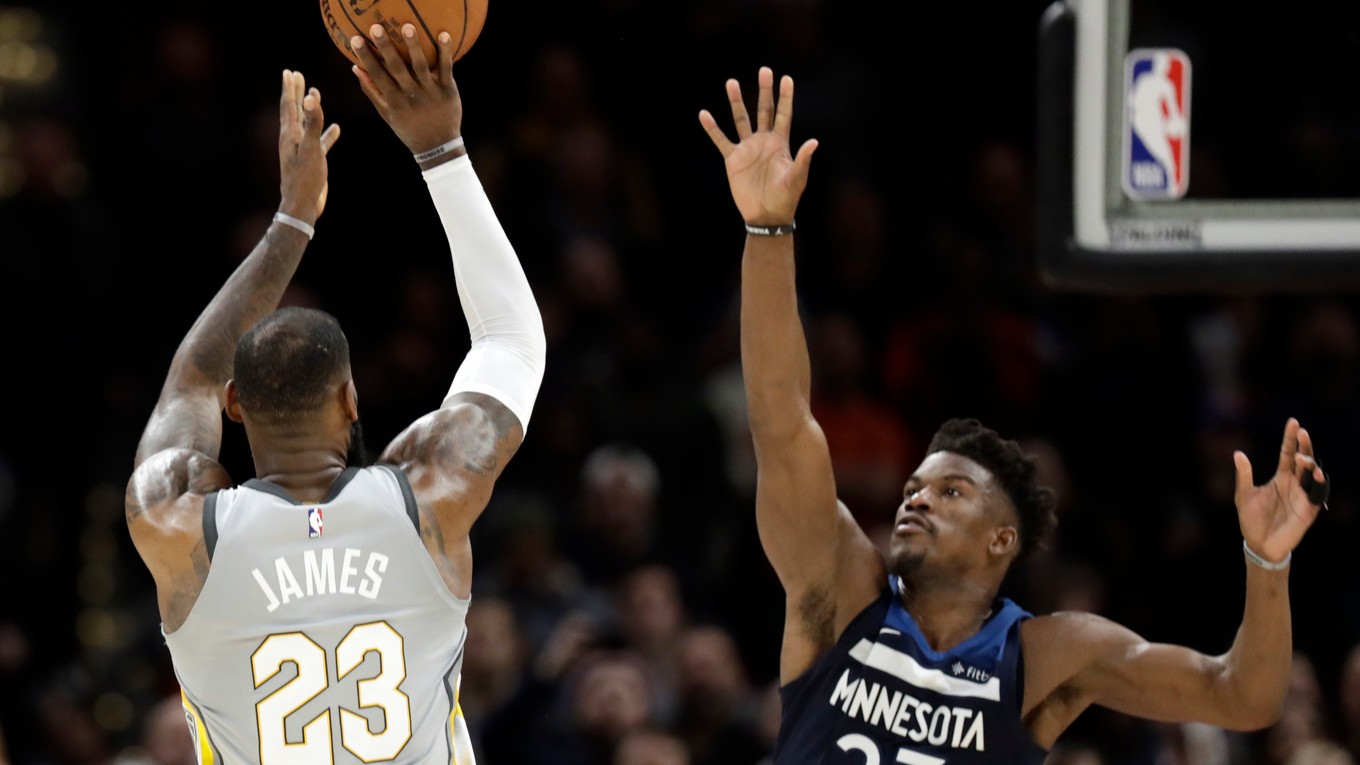 Na snímke vľavo hráč Cavaliers LeBron James dáva kôš v predĺžení, vpravo hráč Minnesoty Jimmy Butler.