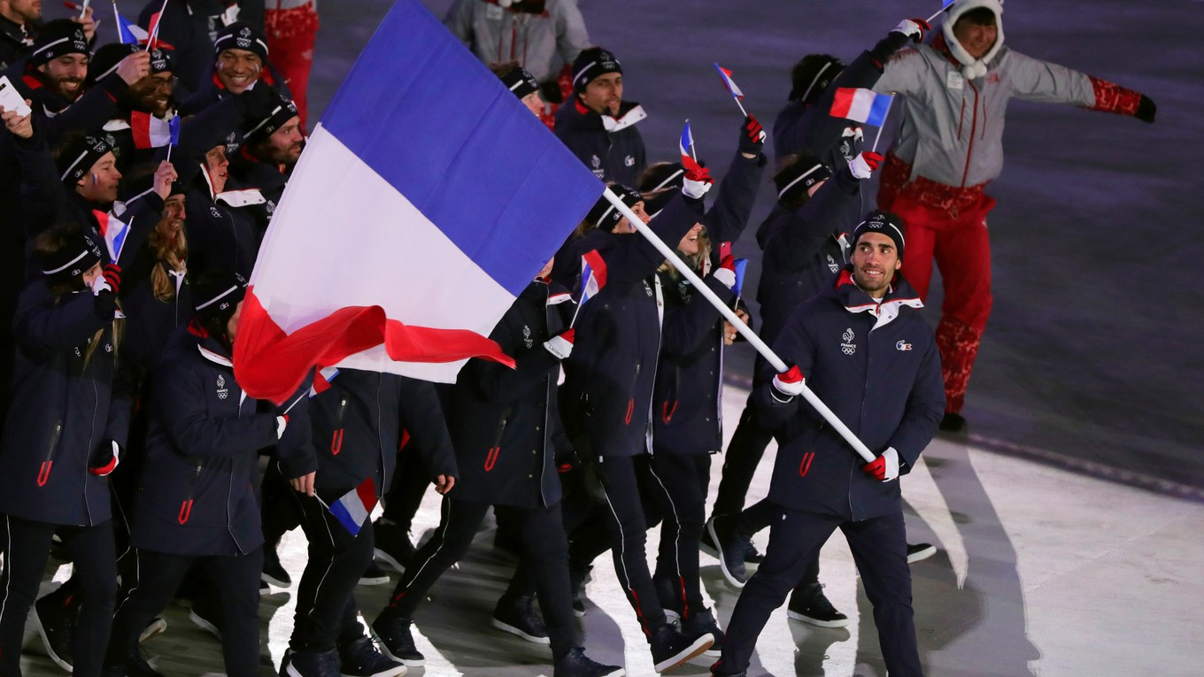 Martin Fourcade s vlajkou v rukách privádza francúzsku výpravu na otvárací ceremoniál.