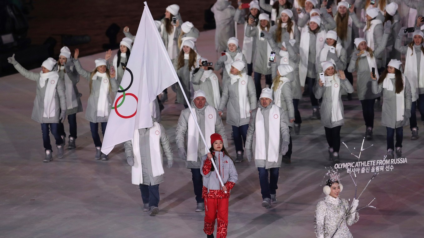 Na otváracom ceremoniáli kráčali Olympijskí športovci z Ruska pod olympijskou vlajkou, ktorú niesla kórejská dobrovoľníčka.