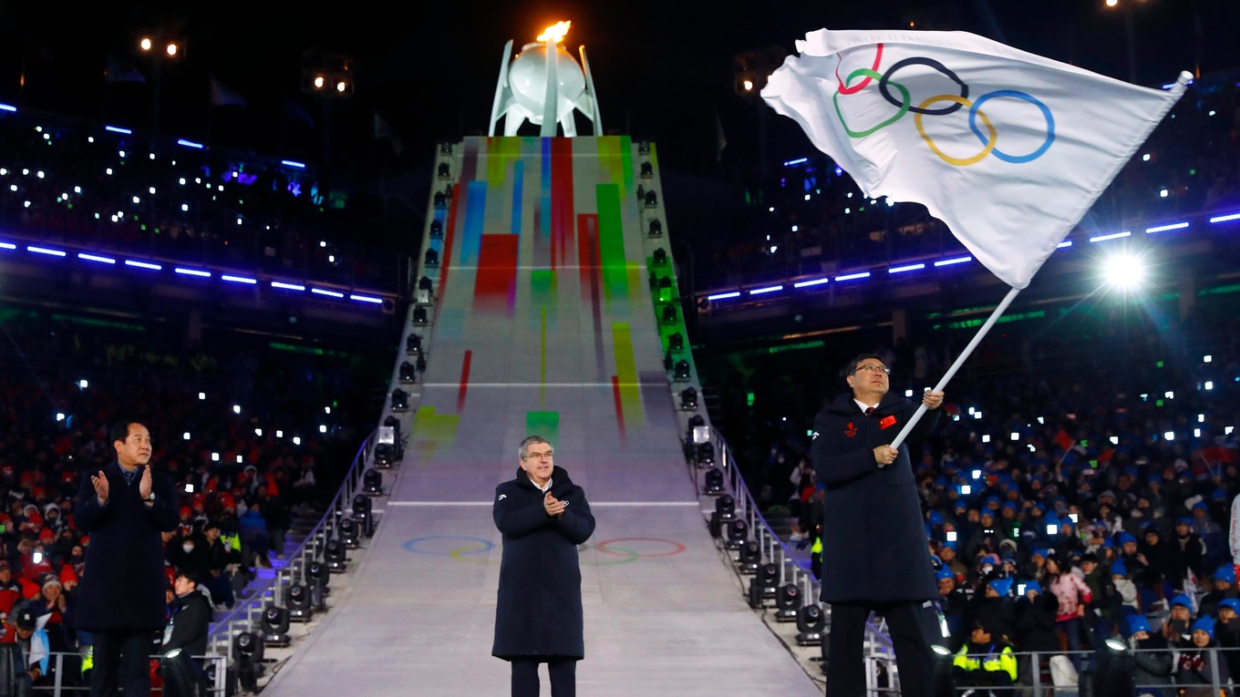 Starosta Pekingu máva olympijskou vlajkou.