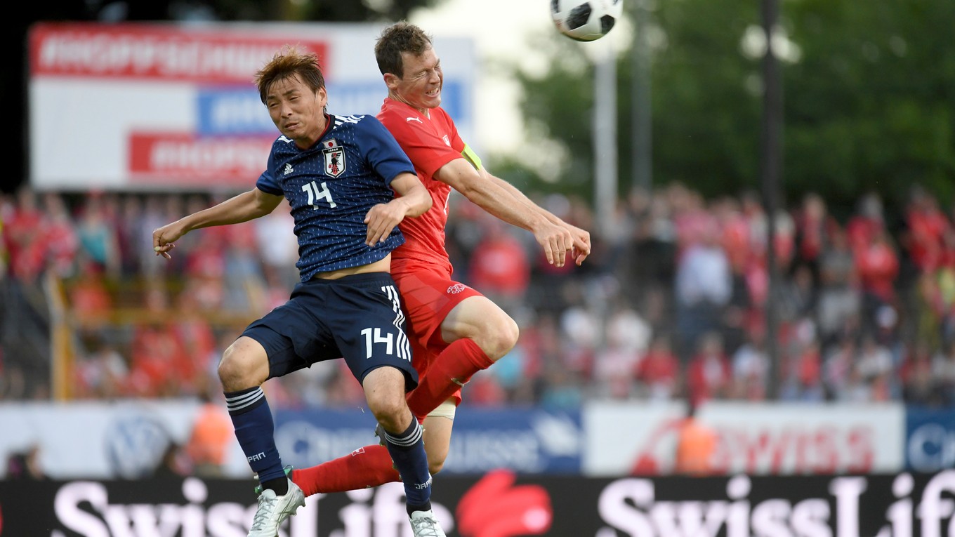Stephan Lichtsteiner (vpravo) zvádza hlavičkový súboj s Japoncom Takashim Inuim.