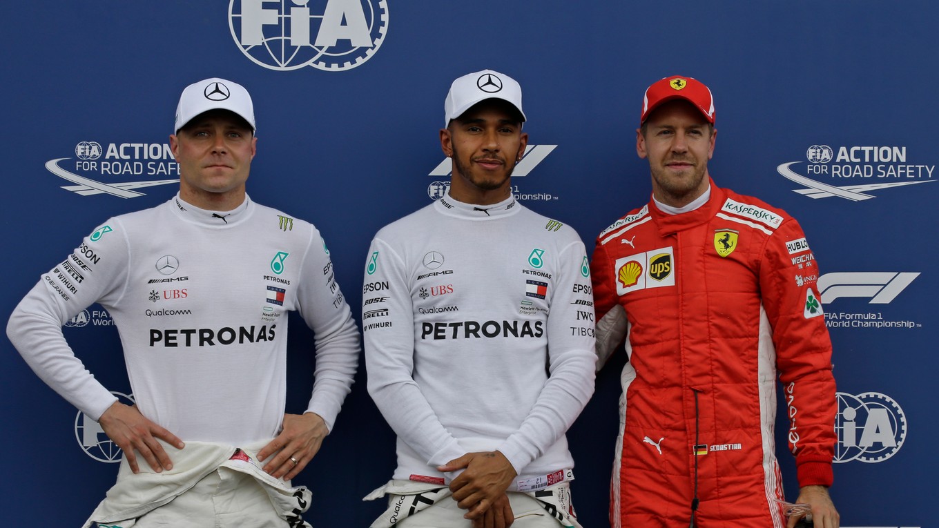 Pred objektívmi fotografov pózujú traja najlepší zo sobotňajšej kvalifikácie - zľava druhý Valtteri Bottas, prvý Lewis Hamilton a tretí Sebastian Vettel.