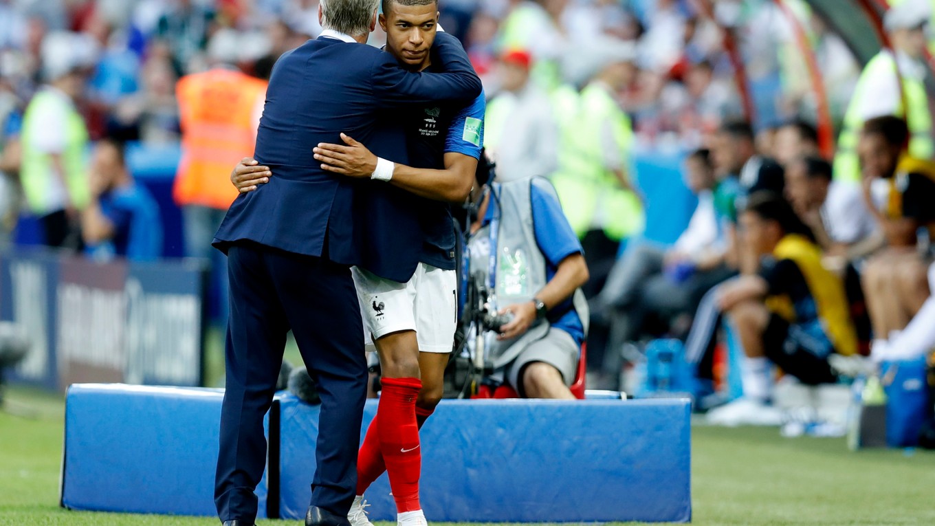 Kylian Mbappé v objatí reprezentačného trénera Didiera Deschampsa.