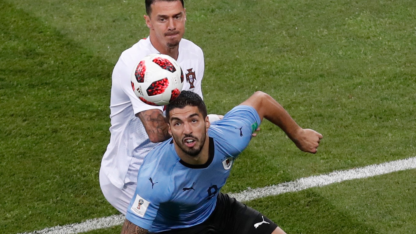 Na snímke z MS vo futbale 2018 José Fonte (vzadu) bojuje o loptu s Luisom Suárezom.