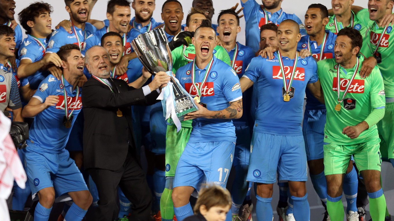 Na snímke uprostred slovenský stredopoliar a kapitán SSC Neapol Marek Hamšík, naľavo šéf klubu Aurelio De Laurentiis oslavujú s trofejou titul v talianskom futbalovom Superpohári v roku 2014, archívna snímka.