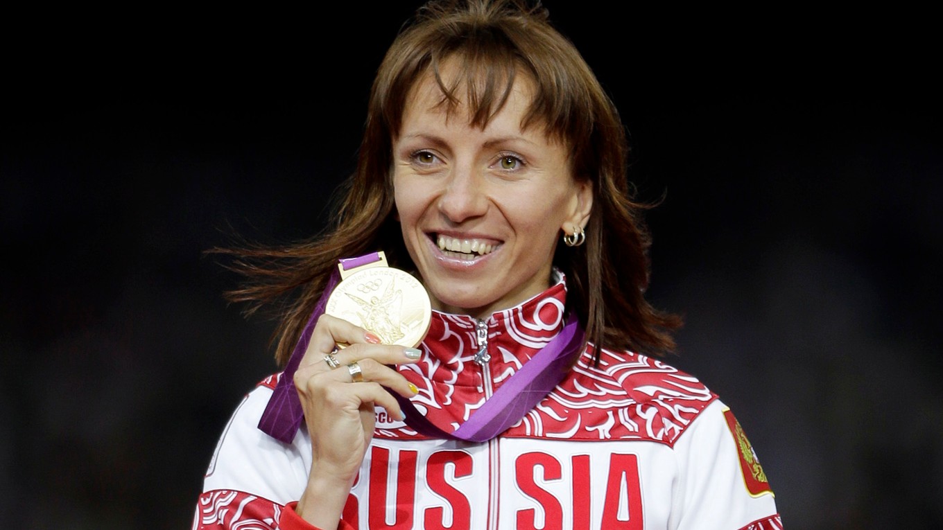 Na archívnej snímke z 11. augusta 2012 ruská bežkyňa Maria Savinovová ukazuje zlatú medailu, ktorú získala na 800 metrov na OH v Londýne.