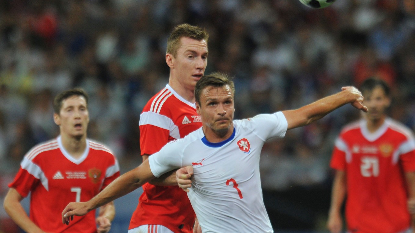 Ruský reprezentant Andrej Semenov atakuje českého súpera Stanislava Tecla v bielom drese. 