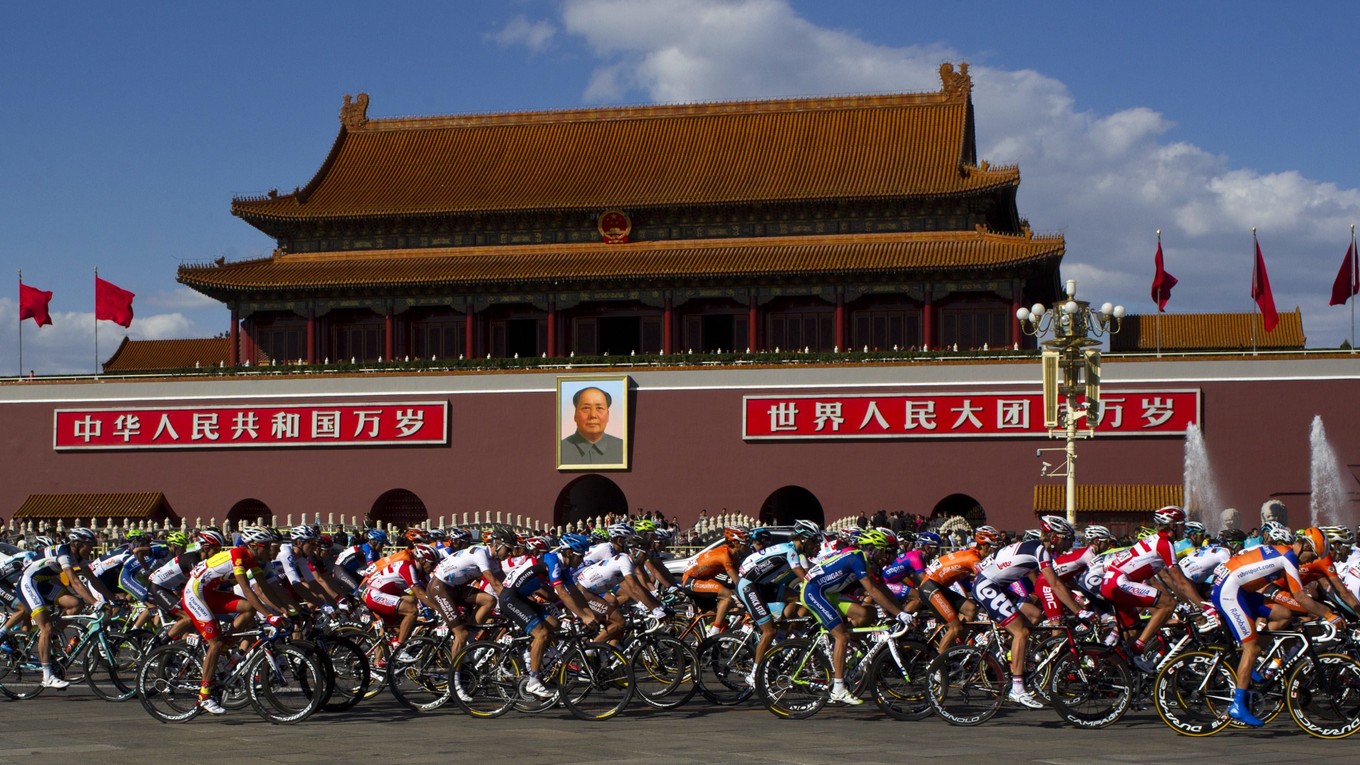 Cyklisti prechádzajú cez Námestie brány nebeského pokoja v Pekingu.
