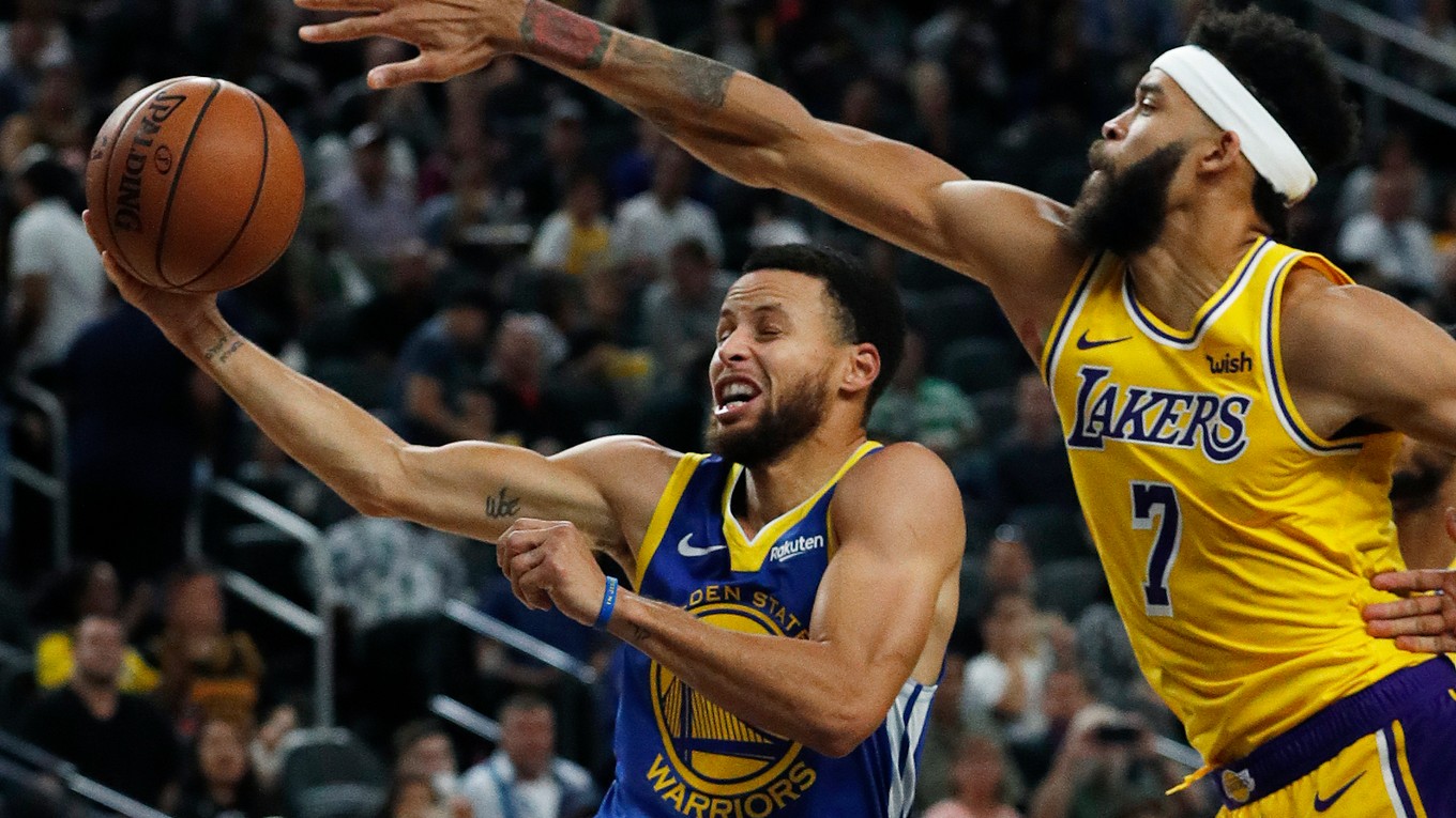 Stephen Curry z Golden State Warriors sa pokúša zakončiť cez JaValea McGeeho z Los Angeles Lakers.