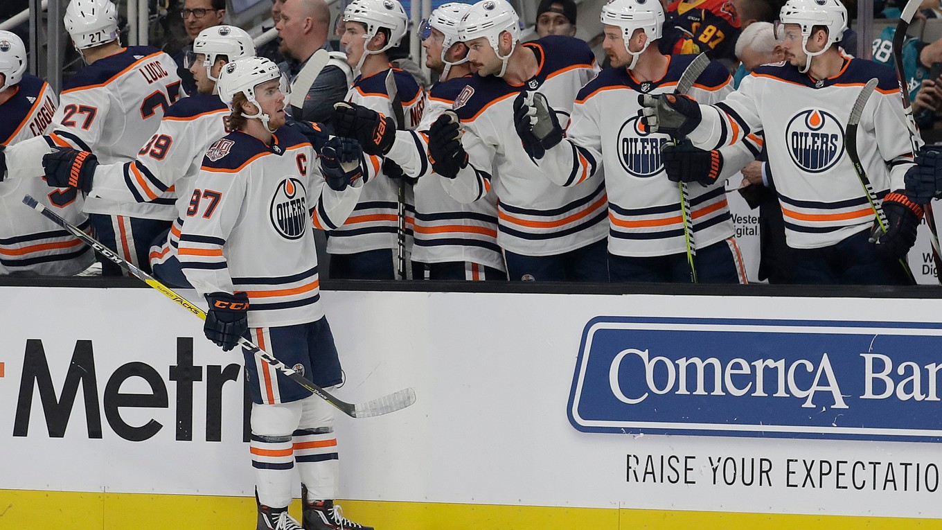 Connor McDavid príjima od spoluhráčov gratulácie k stému gólu v NHL.