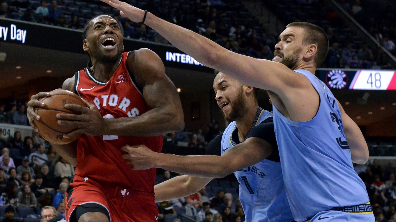 Hráč tímu Toronto Raptors Kawhi Leonard útočí, Kyle Anderson (1) a Marc Gasol v modrých dresoch Vancouveru Grizzlies ho bránia.