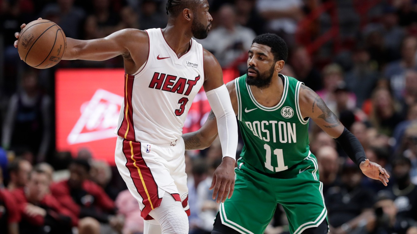 Dwyane Wade (vľavo) z Miami Heat pred brániacim Kyrieom Irvingom z Bostonu Celtics.