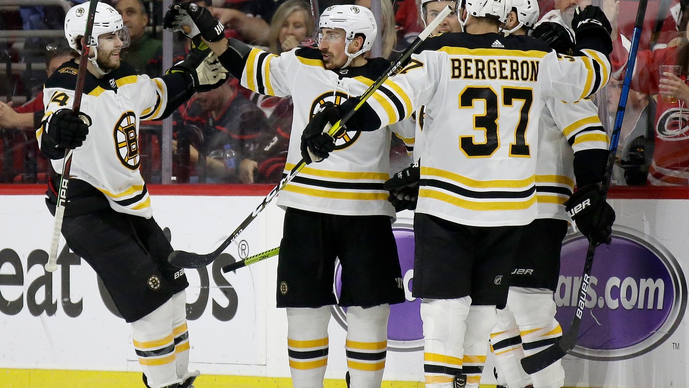 Hokejisti Bostonu Bruins oslavujú gól v zápase proti Caroline Hurricanes.