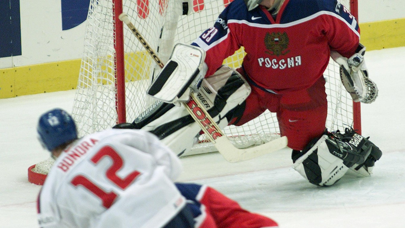 Maxim Sokolov inkasuje gól od Petra Bondru na MS v hokeji 2002.