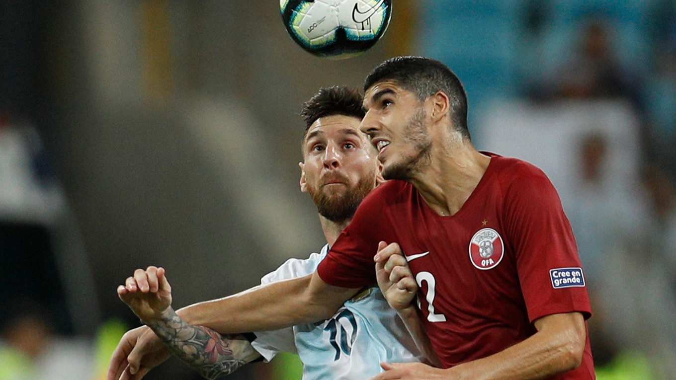 Lionel Messi v súboji s reprezentantom Kataru Karimom Boudiafom. 