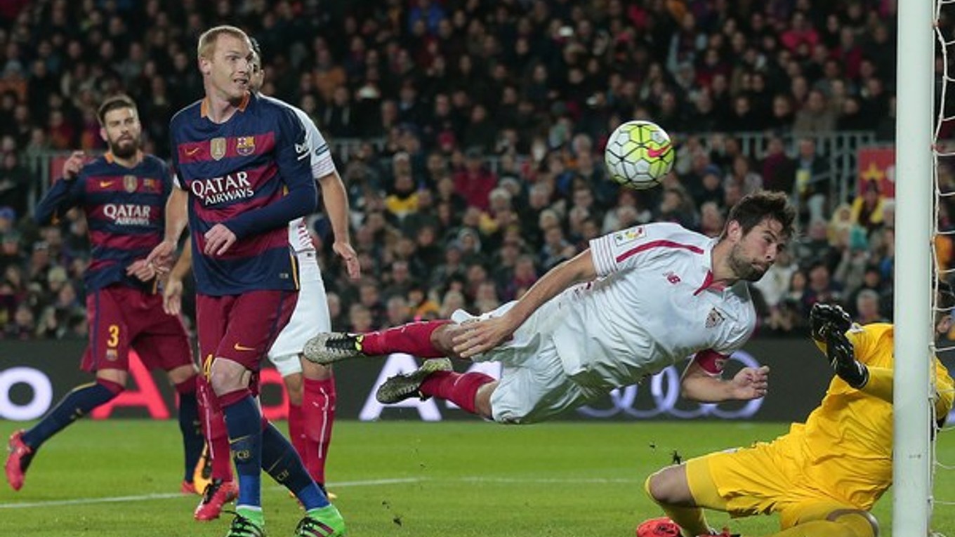 Hráč Coke z FC Sevilla (druhý sprava) zvádza súboj o loptu v pokutovom území s Jeremym Mathieum z FC Barcelona (druhý zľava).