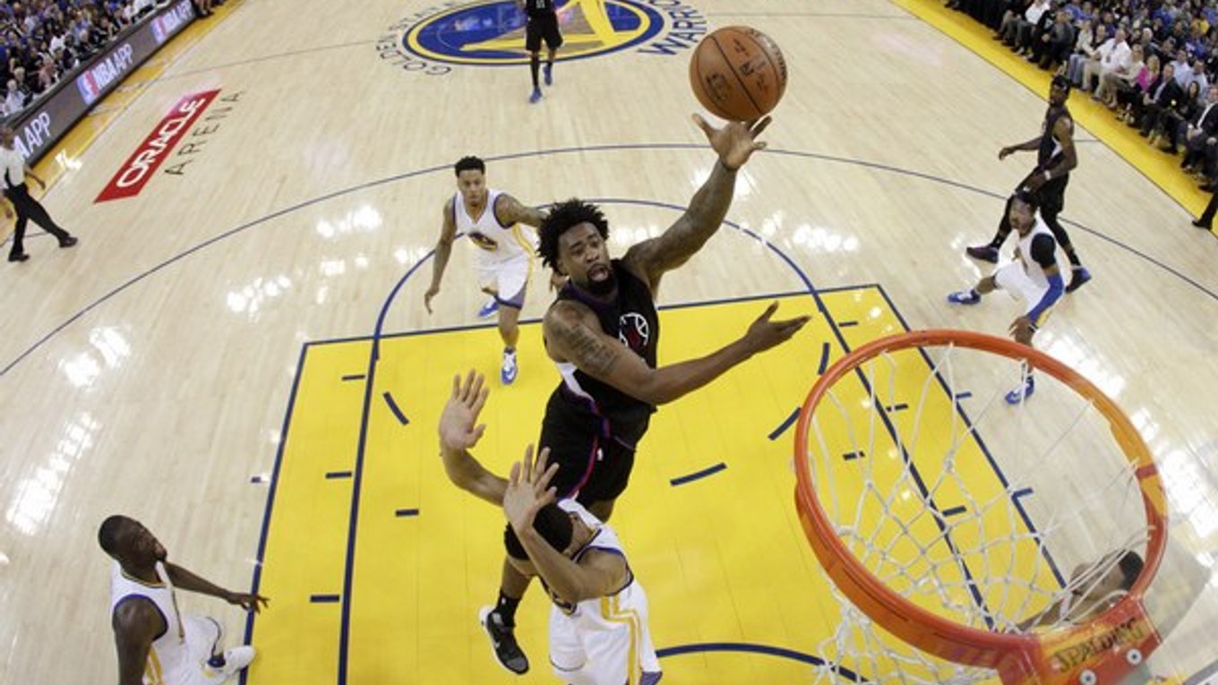 Basketbalista Los Angeles Clippers DeAndre Jordan (vo výskoku) sa pokúša skórovať v zápase na palubovke Golden State.