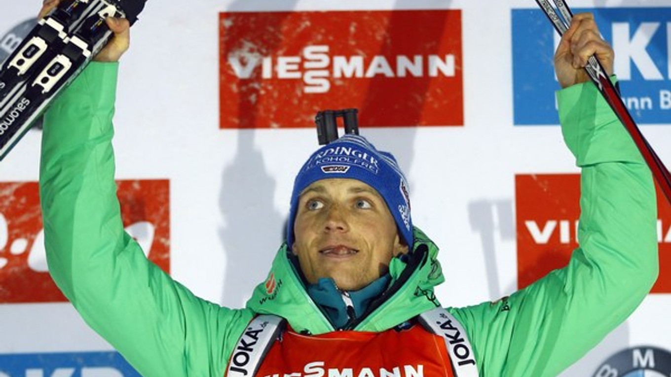 Nemecký biatlonista Erik Lesser oslavuje na pódiu víťazstvo pretekov na 15 km s hromadným štartom.