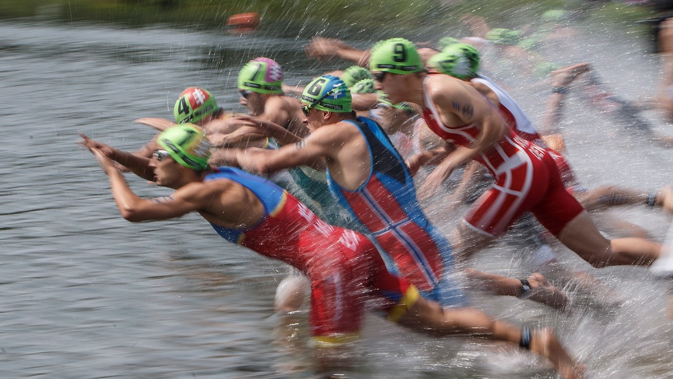 Triatlonisti skáču do vody počas plaveckej časti na šiestom podujatí Svetovej série ITU v kanadskom Edmontone 29. júla 2017. 
