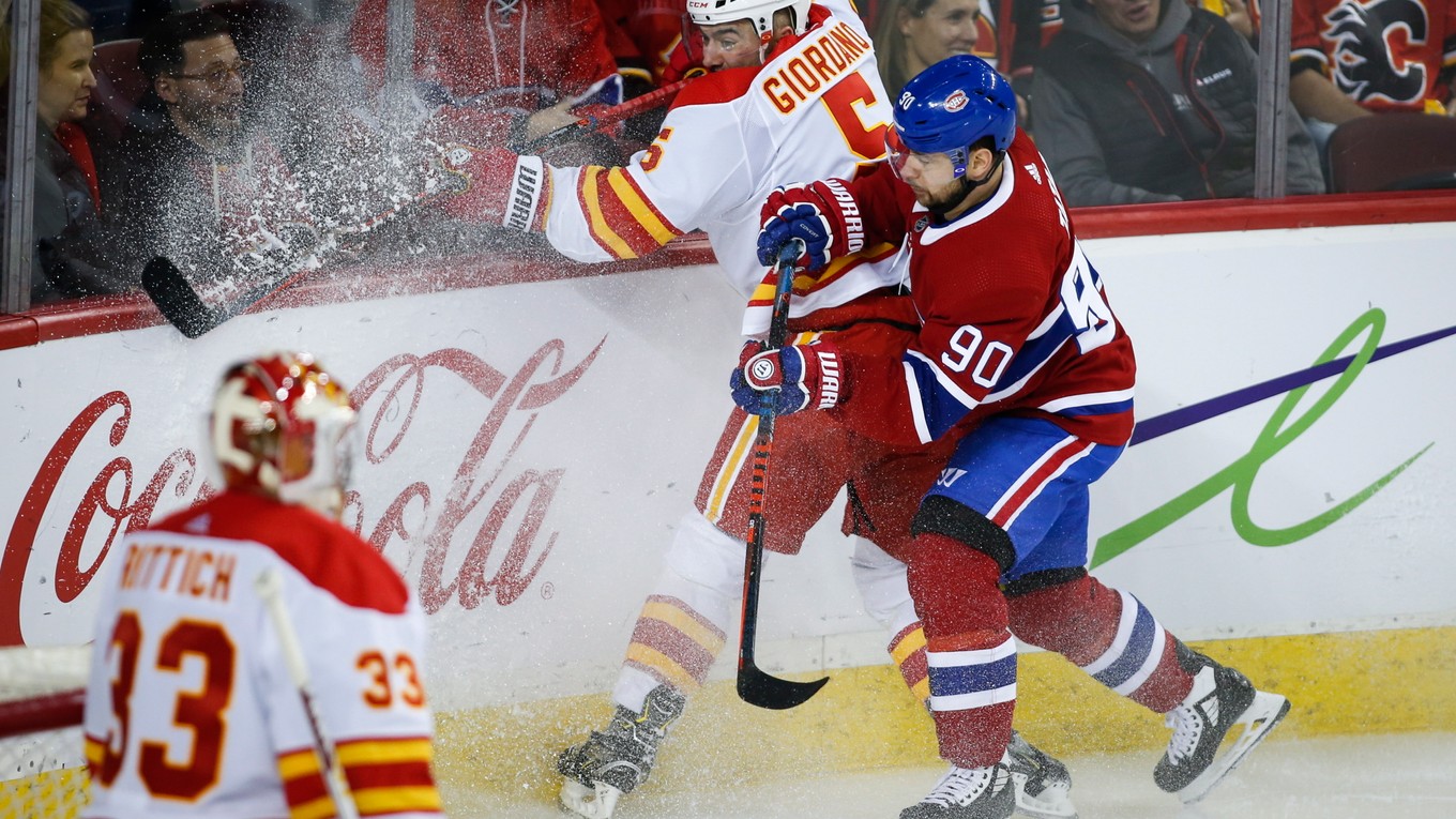 Tomáš Tatar atakuje protihráča Marka Giordana z Calgary Flames.