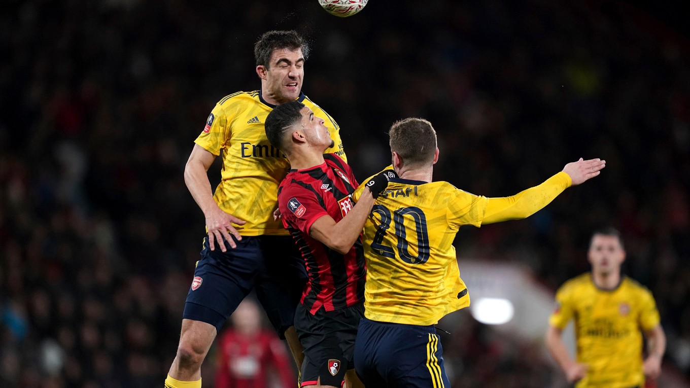 Sokratis Papastathopoulos (vľavo) a Shkodran Mustafi (vpravo) bojujú o loptu s Dominicom Solankem v zápase AFC Bournemout - Arsenal FC.