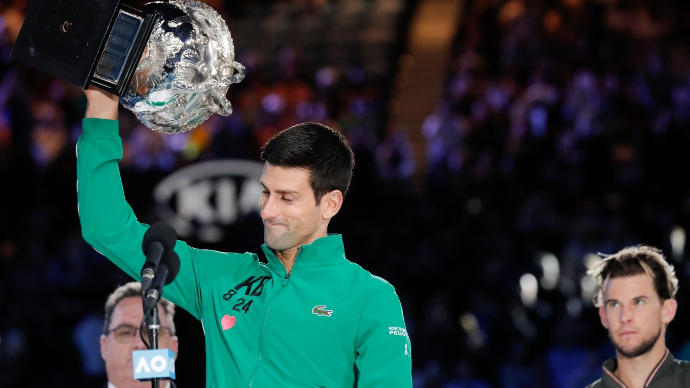 Novak Djokovič s trofejou pre víťaza Australian Open, v pozadí finalista Dominic Thiem.