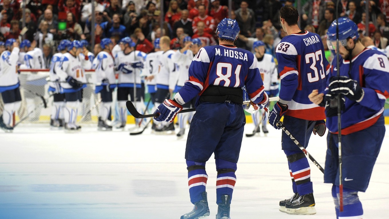 Sklamaní slovenskí hokejisti sledujú fínsku radosť.