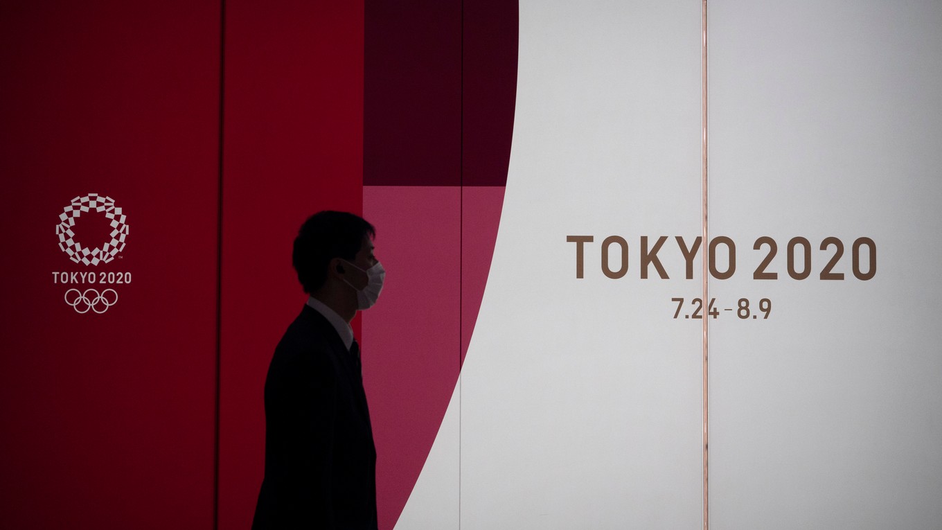 Muž kráča okolo reklamného transparentu tohtoročných letných olympijských hier v Tokiu v pondelok 23. marca 2020.
