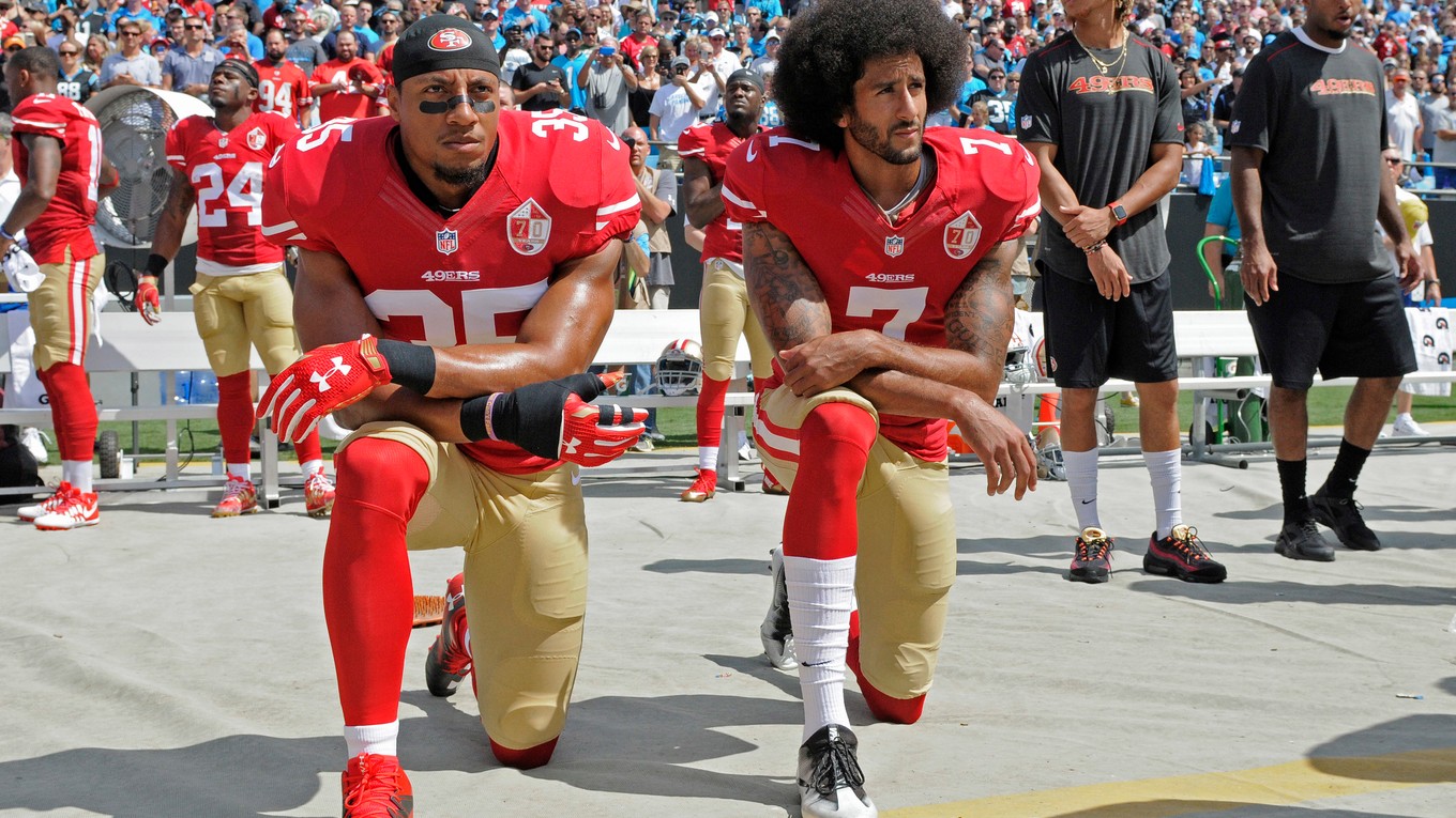 Hráči amerického futbalu z tímu San Francisco 49ers Colin Kaepernick (7) a Eric Reid (35) kľačia počas hymny pred začiatkom zápasu NFL.