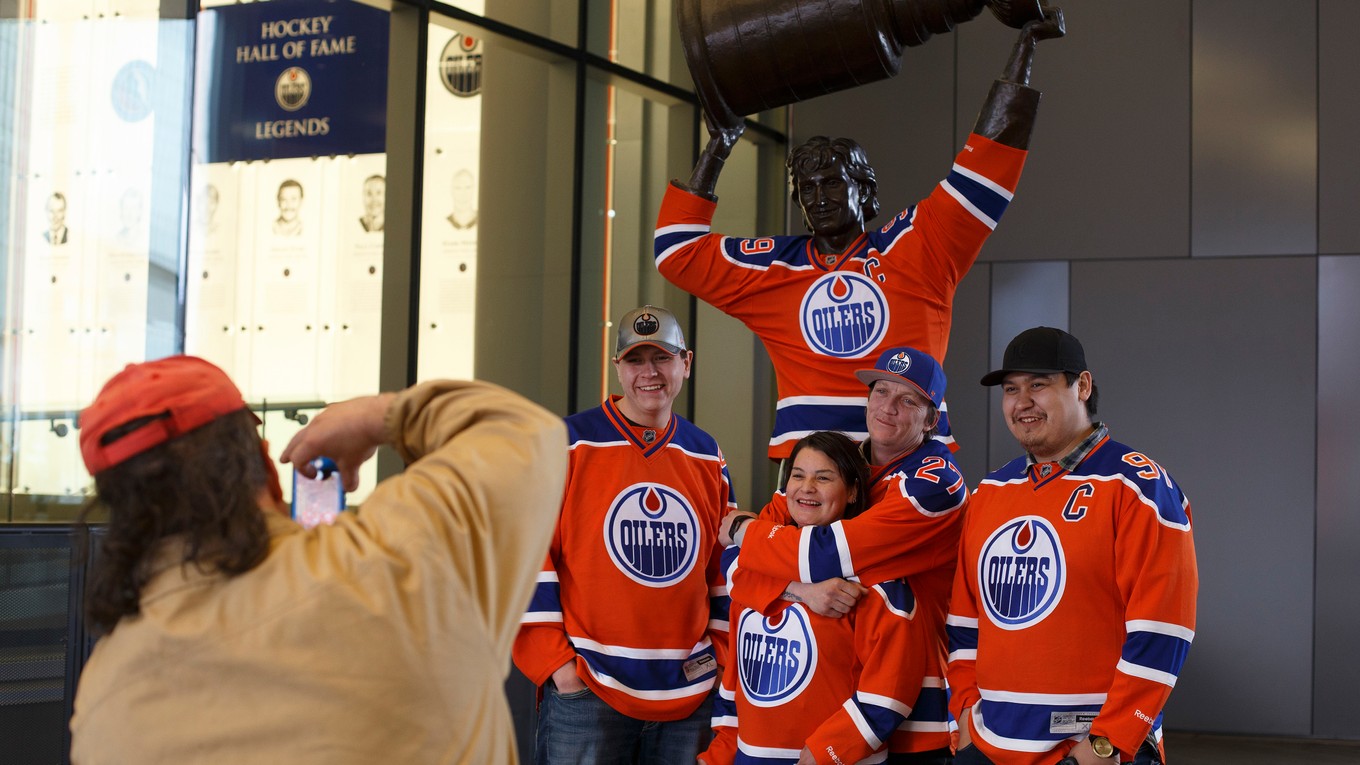 Fanúšikovia Edmontonu sa fotia pri soche Wayna Gretzkého pred štadiónom Oilers.