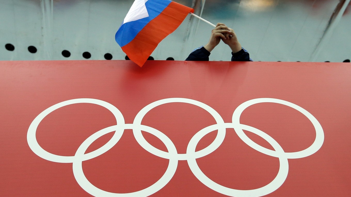 Na archívnej snímke drží fanúšik drží ruskú vlajku nad olympijskými kruhmi.
