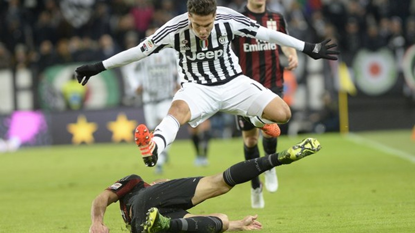 Juraj Kucka z AC Miláno (vľavo) posiela sklzom k zemi Hernanesa z Juventusu.