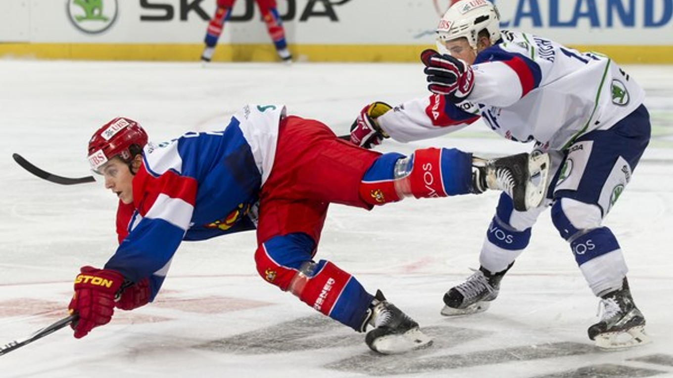 Obranca Jokeritu Helsinki Atte Ohtamaa padá na ľad po zákroku Martina Buchwiesera z Adleru Mannheim.